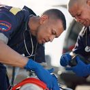 Rettungssanitäter versorgen fokussiert einen Patienten